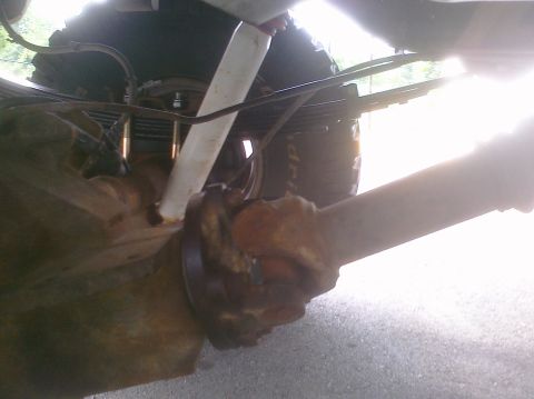 1995 Ford Bronco - Close-up of the undercarriage reveals the vehicle's rear axle and suspension system.