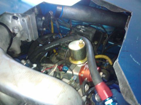 1995 Ford Probe - Close-up view of a modified engine bay, showing various hoses, a fuel pressure regulator, and other components under a blue exterior panel.
