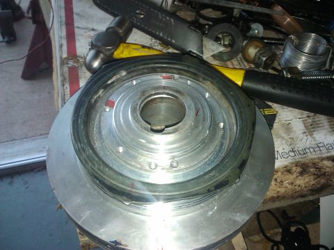 1995 Ford Probe - Close-up of a crankshaft pulley with a hammer and utility knife nearby.