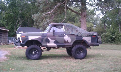 1979 Ford Bronco - Modified 1979 Ford Bronco with camouflage paint and a tarp covering the rear section.