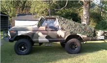 1979 Ford Bronco - This 1979 Ford Bronco is covered in camouflage, blending into its outdoor surroundings.
