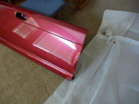 1997 Dodge 2500 - A red vehicle door is shown, partially covered by white protective material.