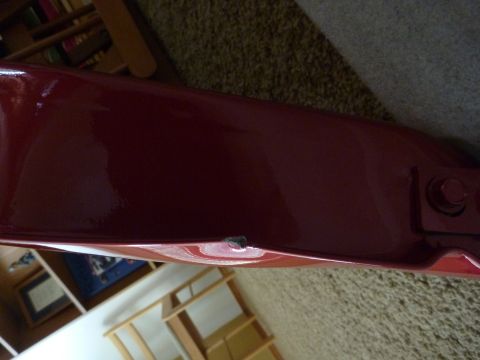 1997 Dodge 2500 - Close-up of a red painted metal panel with a small dent.