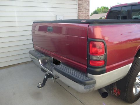 1997 Dodge 2500 - Rear view of a red 1997 Dodge 2500 pickup truck parked next to a garage.