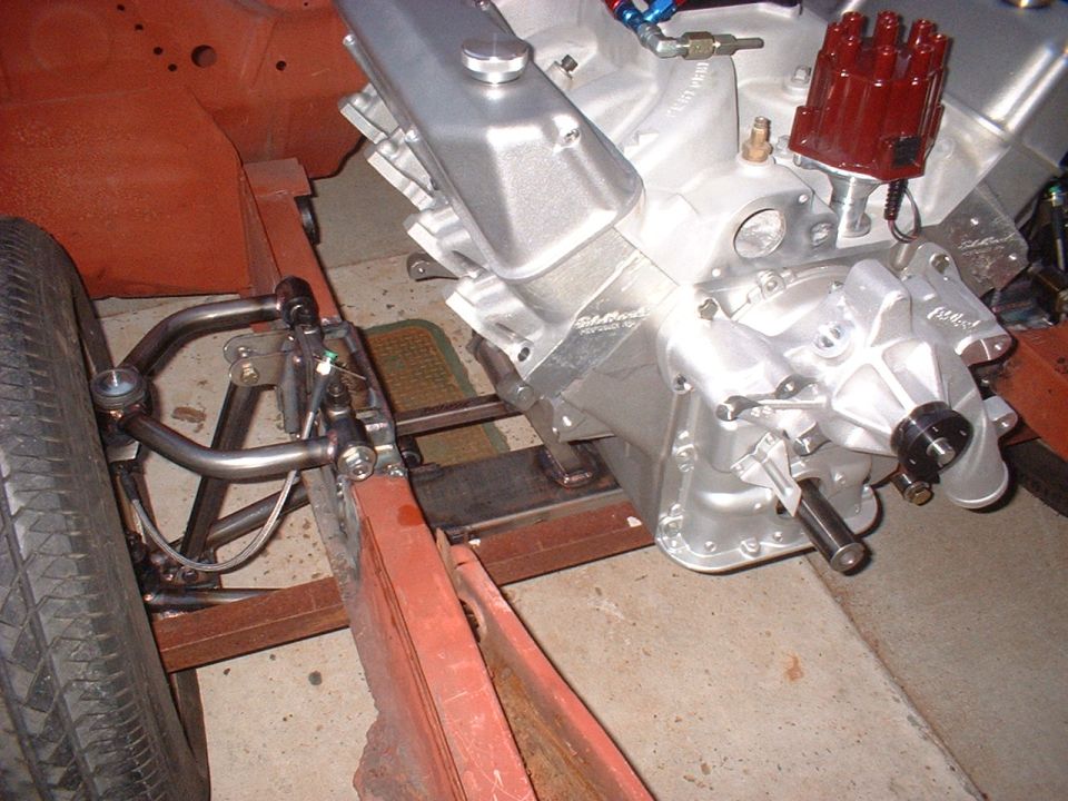 Engine block and front suspension parts of a car, with a tire visible on the left