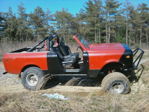 1978 International Scout II - This 1978 International Scout II features a two-tone red and black paint scheme, a roll cage, and off-road tires, ready for adventure.