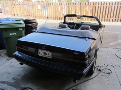 1985 Ford Mustang - This dark blue convertible appears to be a 1985 Ford Mustang, viewed from the rear.