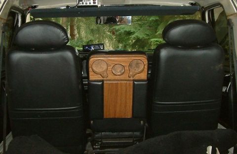 1983 Ford Bronco - The interior features black bucket seats and a custom wooden console with three gauges.