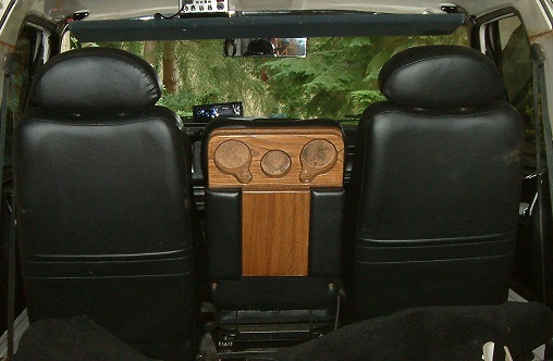 Interior view of black seats and wooden console with gauges