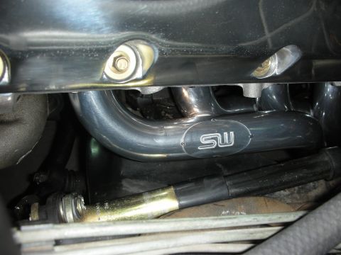 1992 Ford Crown Victoria - Close-up of an engine exhaust manifold an SW logo, likely a performance part.