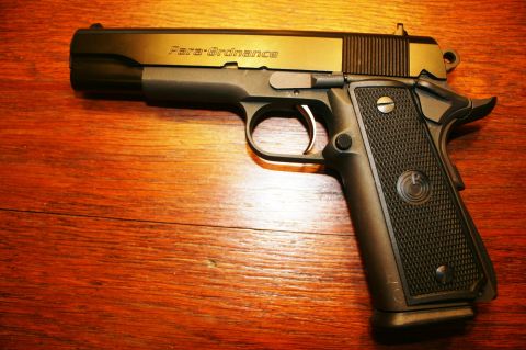 2006 Mazda 3 - A black Para-Ordnance pistol is shown from the side on a wooden table.
