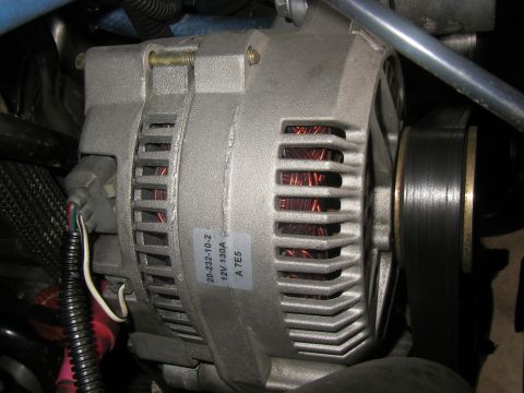 1990 Ford Bronco - A close-up view of a vehicle's alternator, showing a part number and amperage rating on a sticker.