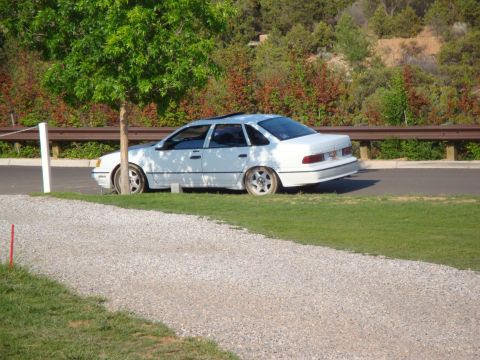 1990 Ford Taurus - White 1990 Ford Taurus sedan parked on grass.