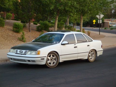 1990 Ford Taurus - This 1990 Ford Taurus sedan, seen from a 3/4 front angle, features a contrasting black hood.