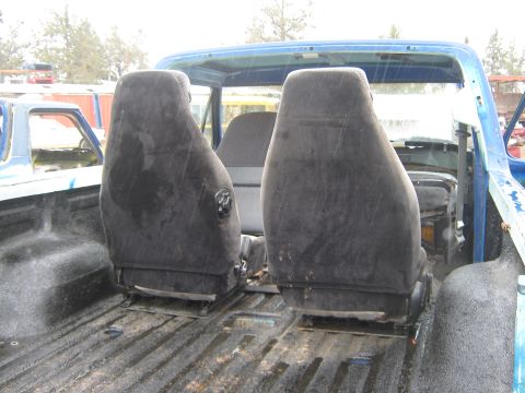 1978 Ford Bronco - Interior of a blue truck bed with seats visible, another vehicle is in the background.