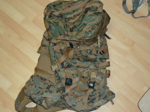 1992 Ford Mustang - A large military backpack in camouflage pattern lies on a wooden floor.