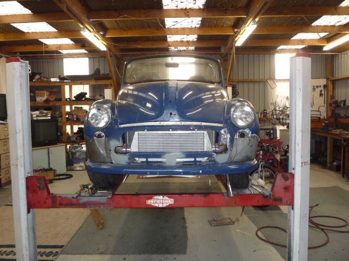 Blue classic project car on a two-post lift with front-mount intercooler in the grille