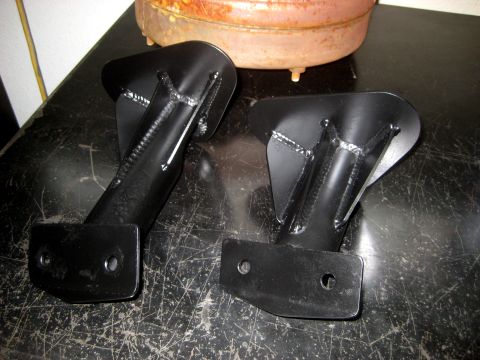 1996 Ford Bronco - Two black metal transfer case skid plates are shown, each with visible welds and mounting holes.