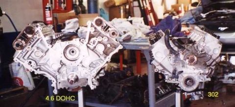 1997 Ford Taurus - Two V8 engines are displayed, with one clearly marked as a 4.6 DOHC, likely in a repair or parts setting.