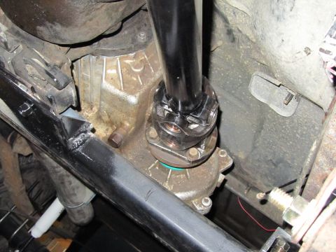 1984 Ford Bronco - Underside view of a vehicle's drivetrain, focusing on the transfer case and driveshaft connection.