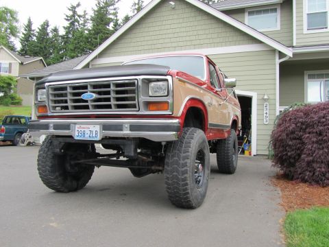 1984 Ford Bronco - This lifted Ford Bronco has a two-tone paint scheme and is parked in front of a house.