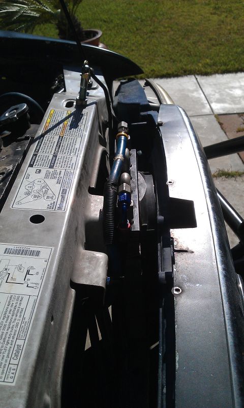 1992 Ford Ranger - Close-up view of engine bay components, including hoses and a fan, under the hood of a vehicle.
