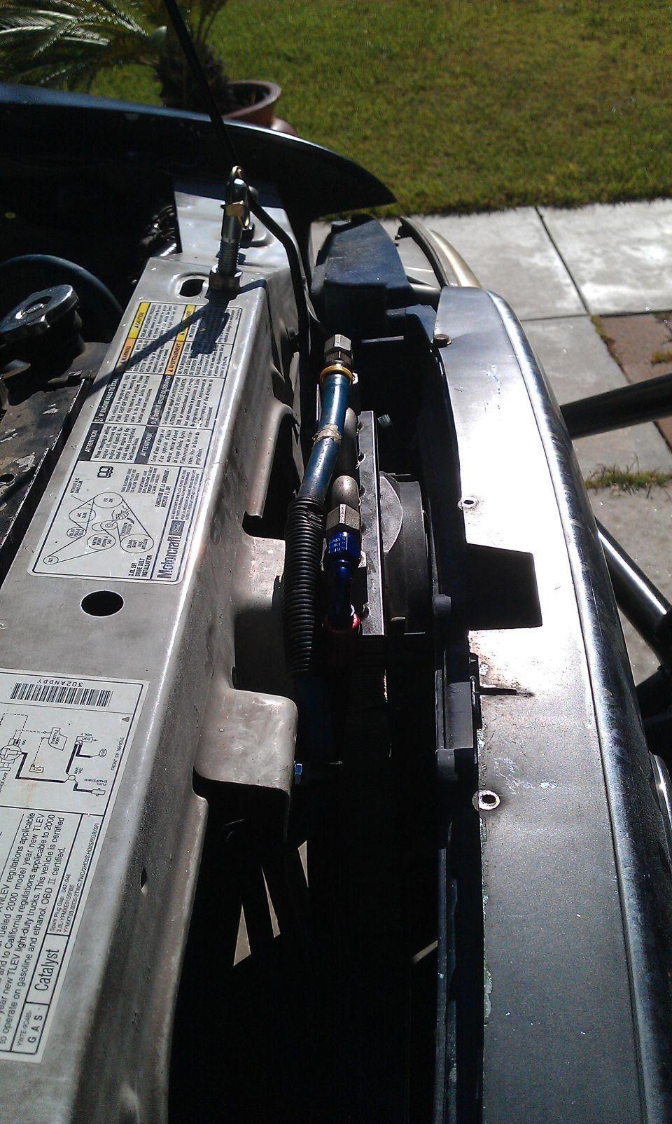 engine bay with hoses and fan visible