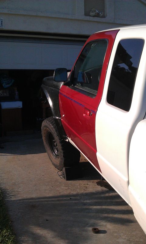 1992 Ford Ranger - A Ford Ranger truck with a red door and white rear panel is parked in front of a garage.