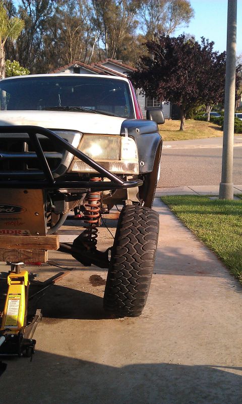 1992 Ford Ranger - Front end of a 1992 Ford Ranger undergoing suspension work, with a jack and jack stands visible.
