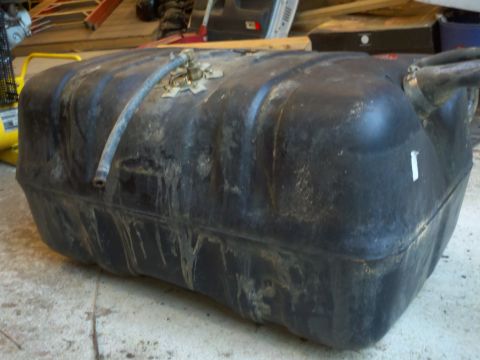 1979 Ford Bronco - This is a black plastic fuel tank, likely for an older vehicle, with visible metal fittings and hoses attached.