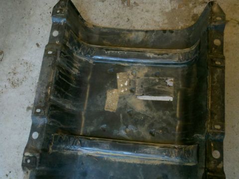 1979 Ford Bronco - This is a close-up view of the underside of a dirty, black metal automotive part.