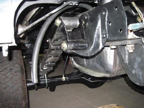 1979 Ford Bronco - Close-up view of a vehicle's rear suspension components and fuel tank.