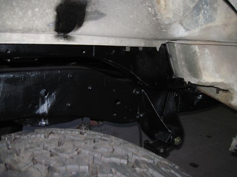 1979 Ford Bronco - Underside view of a vehicle's frame and tire, with visible black paint.