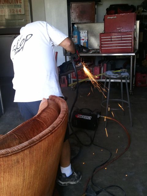 1982 Ford Bronco - A person is welding in a workshop, with sparks flying from the metalwork.