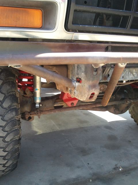 1982 Ford Bronco - Close-up of the front suspension and custom bumper on a 1982 Ford Bronco, highlighting the red coil springs and Bilstein shocks.