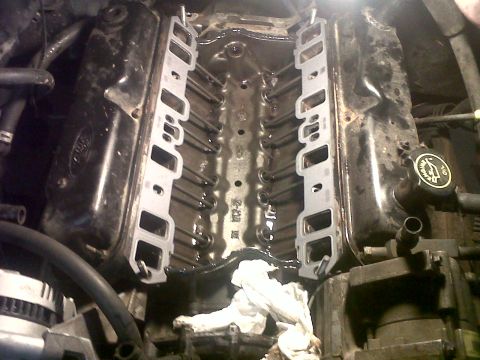 1994 Ford F-150 - Close-up view of an engine's intake manifold with the gaskets detached, revealing the internal components.