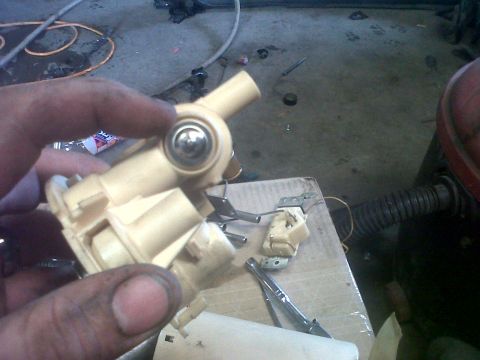 1994 Ford F-150 - A person is holding a disassembled fuel pump assembly, likely for a vehicle repair.