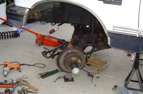 1993 Ford Bronco - This vehicle is being worked on, with the front suspension disassembled and tools scattered around.