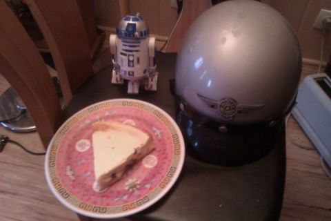 1991 Ford LTD Crown Victoria - A slice of cheesecake sits on a decorative plate beside a R2-D2 toy and a silver helmet.