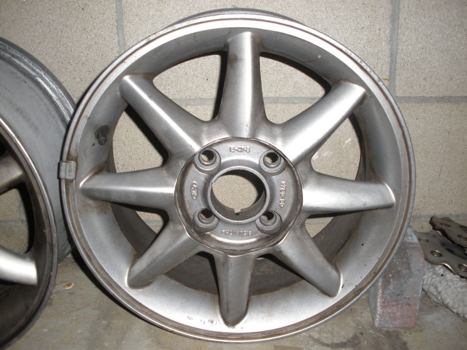Silver 8-spoke alloy wheel with visible lug nut holes and center bore