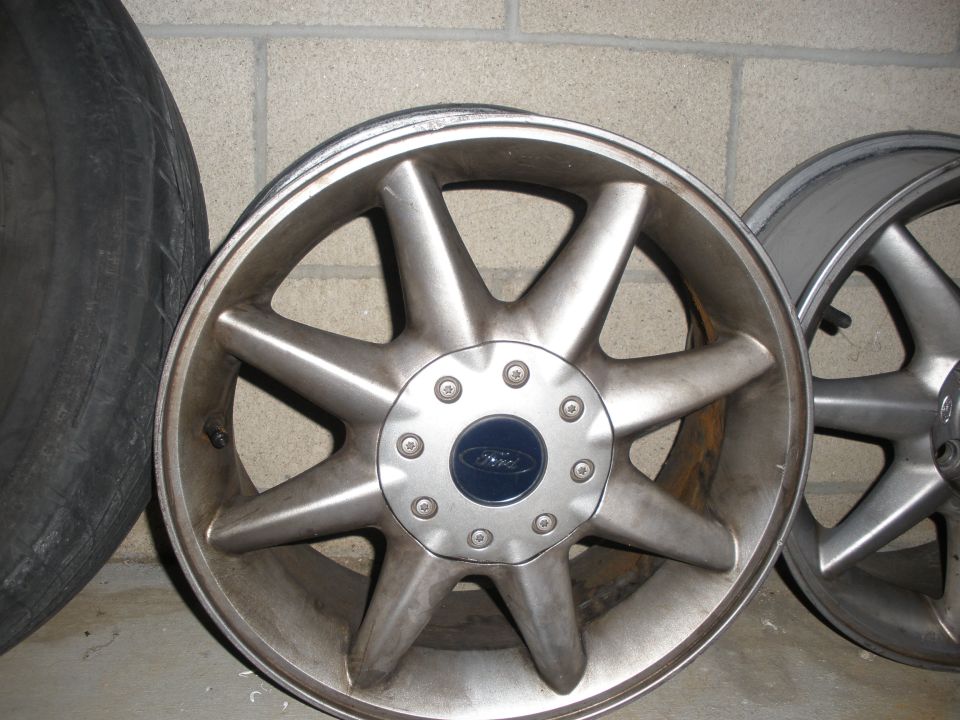 Silver 8-spoke Ford wheel with blue center cap
