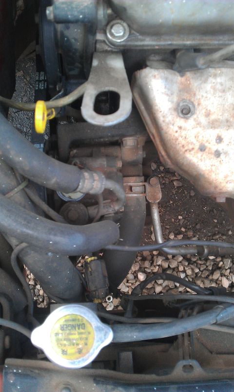 1991 Ford Festiva - The engine bay features various hoses, a yellow dipstick, and a radiator cap with warning text.