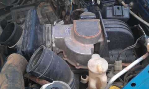 1991 Ford Festiva - Close-up of engine intake manifold and associated hoses, with some text visible on the part.