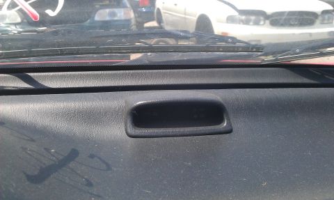 1991 Ford Festiva - Interior view of a dashboard, showing a small storage cubby and the windshield wipers.