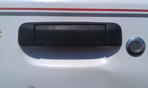 1991 Ford Festiva - A detail shot focuses on the exterior door handle and lock mechanism of a vehicle.