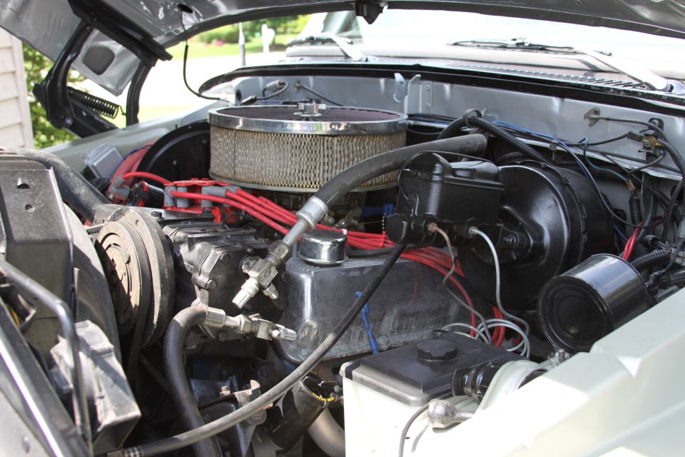 Engine bay with V8 engine, air cleaner, brake booster, and wiring. Watermark says SUPERMOTORS