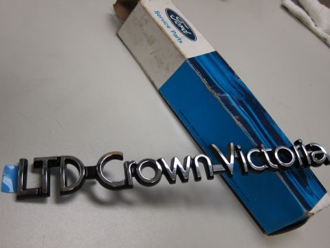 1991 Ford LTD Crown Victoria - A chrome emblem for a Ford LTD Crown Victoria sits on its original Ford Service Parts packaging.