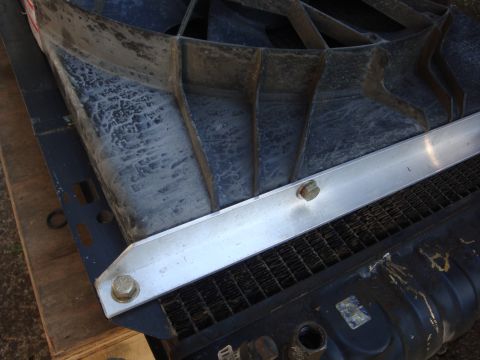 1989 Ford Bronco - Close-up of a vehicle's radiator fan shroud and grille assembly, showing metal bracing and a portion of the radiator.