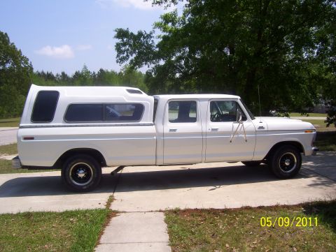 1978 Ford Bronco - This four-door pickup truck features a long bed with a white camper shell, seen from the side on a sunny day.