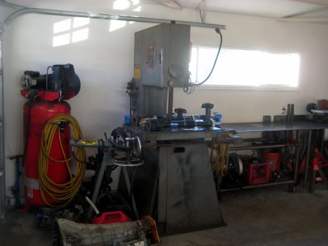 1996 Ford Bronco - Workshop interior with various tools and machinery, including a band saw and air compressor.